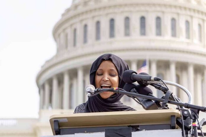 shutterstock_1347895214 Woman in hijab speaking at podium with microphones