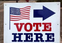 Brazen Admission: Kremlin Ally Targets Midterms voting sign with arrow and American flag