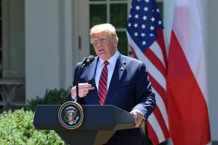 shutterstock_1432764878 Donald Trump speaking at a podium with U.S. and Polish flags behind him