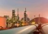 Backdoor Oil Route Shocks The Gulf Oil refinery with pipelines at sunset