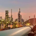 Backdoor Oil Route Shocks The Gulf Oil refinery with pipelines at sunset