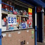 Subsidized Supermarkets Spark Outrage In NYC Convenience store window with EBT and ATM signs