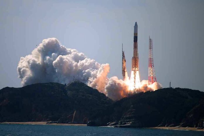 shutterstock_1626273565 Rocket lifts off from coastal launch site with smoke and flames