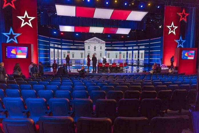 Debate stage with red and blue lighting and empty audience seats