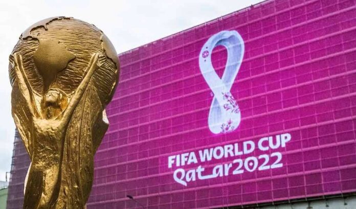 FIFA World Cup trophy in front of Qatar 2022 banner