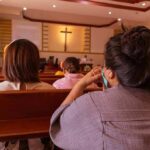 Church Outrage Erupts After Trump Remark people seated in church pews facing a cross