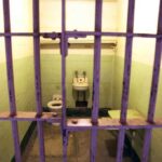 Parole Bombshell Jolts Menendez Saga Interior of a prison cell with a toilet, sink, and metal bars