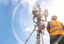 U.S. Loan Supercharges Africa Network Fight Telecom tower with worker in safety vest under bright sky