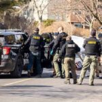Campus Gunfire Sparks Midnight Lockdown Police and sheriff officers gather around vehicles on a suburban street