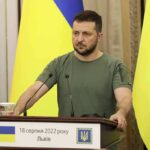 Eight Leaders Drop a Big Ukraine Pledge Man at a podium with Ukrainian flags