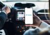 Coercion Claims Rock OnlyFans Agencies Person holding smartphone with OnlyFans app open in a car