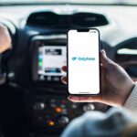 Coercion Claims Rock OnlyFans Agencies Person holding smartphone with OnlyFans app open in a car