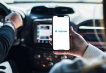 Coercion Claims Rock OnlyFans Agencies Person holding smartphone with OnlyFans app open in a car