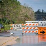 Emergency Powers Hit Indiana Road closed barricades blocking a flooded rural highway with detour sign
