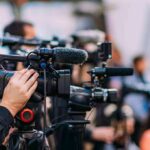 Cash For Class: Detroit’s $1,000 Bet Video cameras on tripods at a media event