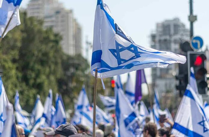 shutterstock_2269386315 Israeli flags waved at a street demonstration