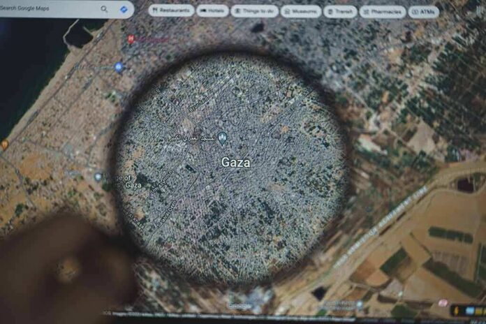 shutterstock_2372300801 Magnifying glass highlighting Gaza on a digital map