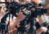 Refinery Chaos Triggers Holiday Price Spike television cameras on tripods at a media event