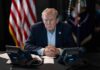 Trump’s Greenland Move Triggers Backlash Donald Trump seated at a table between two desk phones