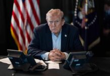 Trump’s Greenland Move Triggers Backlash Donald Trump seated at a table between two desk phones