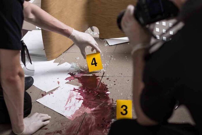 shutterstock_343837214 forensic investigators documenting a bloodstained crime scene