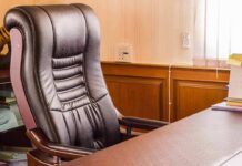 Harassment Probe OUSTS Jersey No. 2 Leather office chair beside a wooden desk