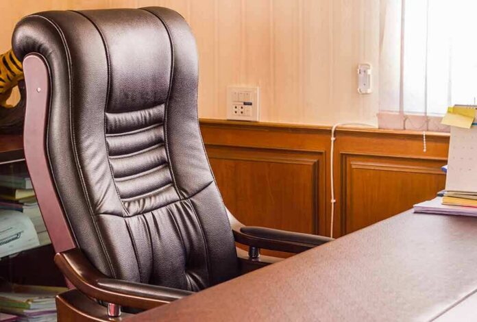 shutterstock_583343320 Leather office chair beside a wooden desk