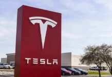 France Greenlights Tesla Road Trials Tesla dealership sign in front of parking lot