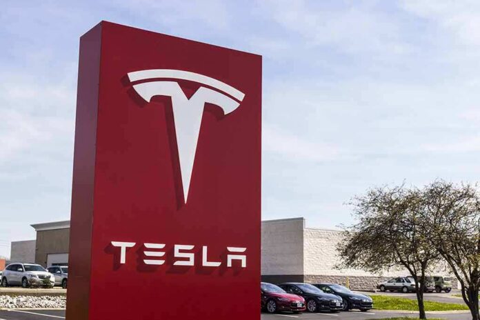 shutterstock_620657588 Tesla dealership sign in front of parking lot