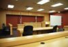 Shocking Custody Twist Rocks Massachusetts Interior view of an empty courtroom with wooden furniture and American flags