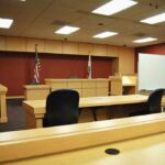 Shocking Custody Twist Rocks Massachusetts Interior view of an empty courtroom with wooden furniture and American flags