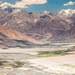 Satellite Snap Reveals Killer Glacier Break Mountain valley with river and snow-capped peaks