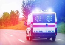 Truck Invades Youth Field – Chaos Erupts Ambulance van with flashing lights on a rural road
