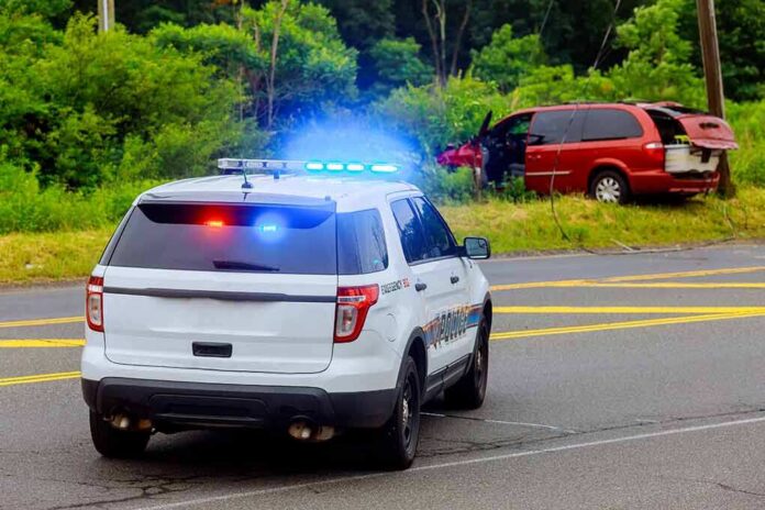 Police SUV with flashing lights at roadside crash scene