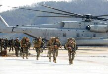 Marine Arrest Triggers Island Lockdown Soldiers disembark and walk past a large military helicopter