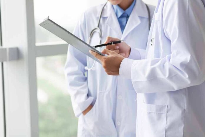 shutterstock_113416138 Doctors reviewing a clipboard