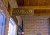 Grand jury sign in a brick-walled hallway