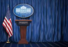 Trump Floats Mass Pardons For Aides White House press briefing podium with U.S. flag and blue curtain