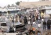 Drone Inferno Guts Crowded Market Crowd gathers at a market after a vehicle explosion