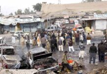 Crowd gathers at a market after a vehicle explosion