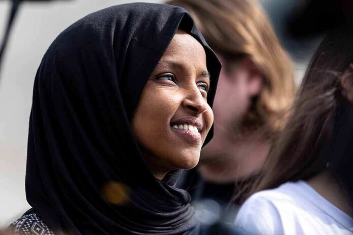 shutterstock_1369298651 Ilhan Omar smiling in a black hijab at an outdoor event
