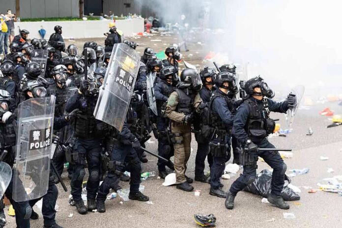 shutterstock_1425188288 Dontrelle Inman and Tom Mandrake among riot police advancing with shields in tear gas