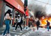Street protest with fire and smoke outside a bank