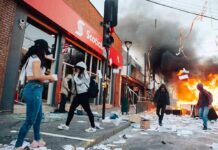 Street protest with fire and smoke outside a bank