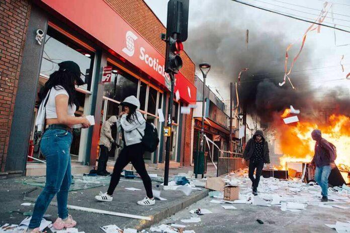 shutterstock_1540874381 Street protest with fire and smoke outside a bank