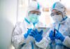 Mystery Pneumonia Triggers Mass Quarantine Two healthcare workers in full PPE reviewing a clipboard