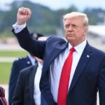 GOP Scramble In Deep-Red Kansas man in suit raising a clenched fist outdoors