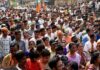 Crowd at a political rally with Kumar Gandharva, Ritu Rani, Jersson Vásquez, Mamata Banerjee, Pravin Amre, Sumrai Tete, Rangana Herath, and Gerson Torres
