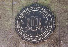 Airport Sting Nabs Alleged China Spy FBI seal mounted on a stone wall