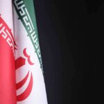 Unannounced Air-Base Meeting Rattles Iran Watchers Iran flag close-up on dark background